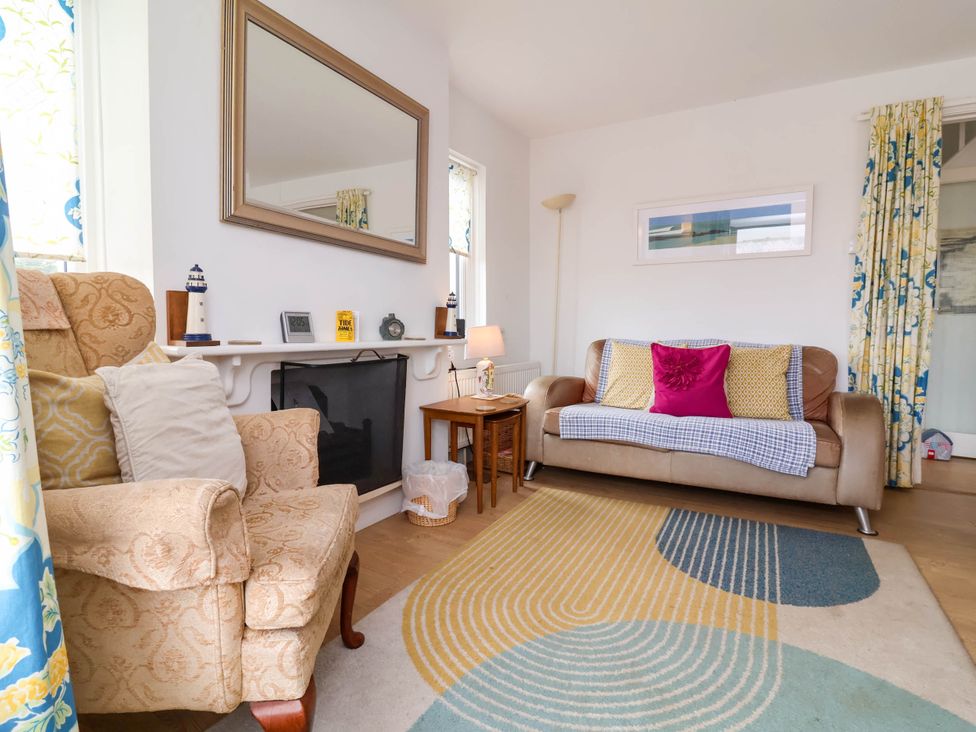 A living room with a sofa and armchair at The Fort in Bude