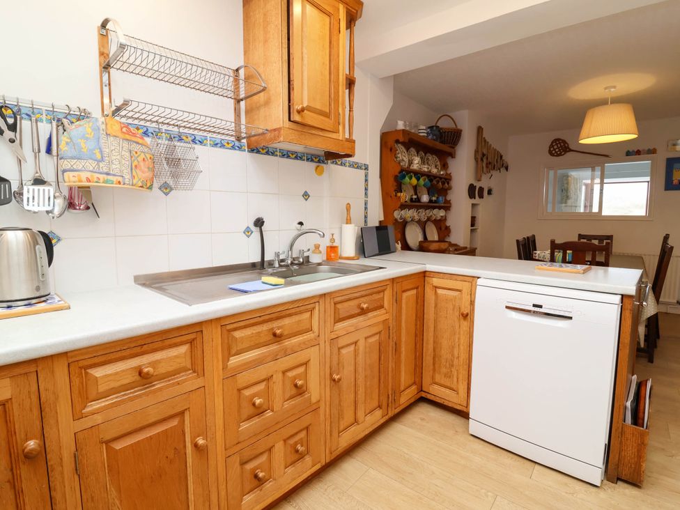 A kitchen with wooden cabinets and a sink at The Fort in Bude