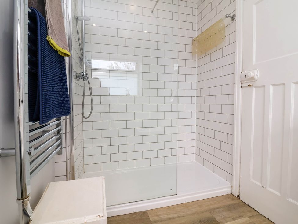 A bathroom with a shower and towel rack at The Fort in Bude