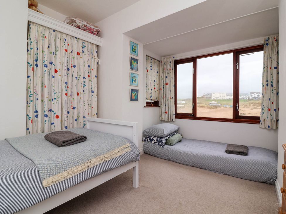 A bedroom with two beds and windows at The Fort in Bude