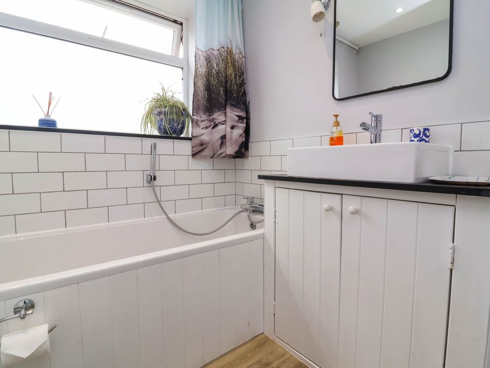 A bathroom with a bathtub and sink at The Fort in Bude