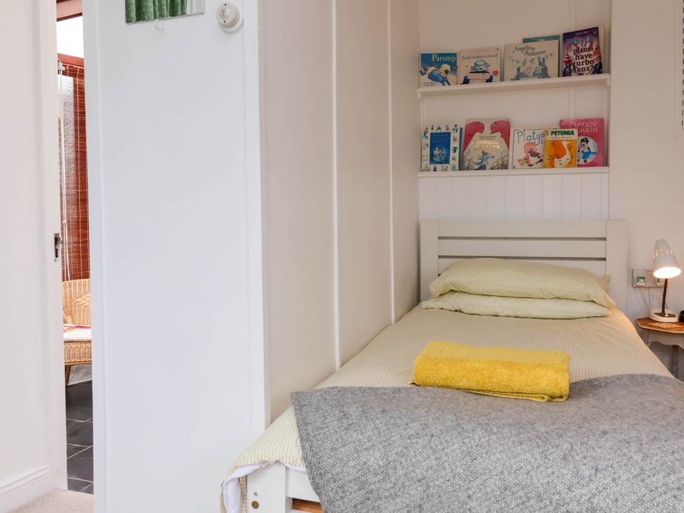 A bedroom with a bed and books on a shelf at The Fort in Bude
