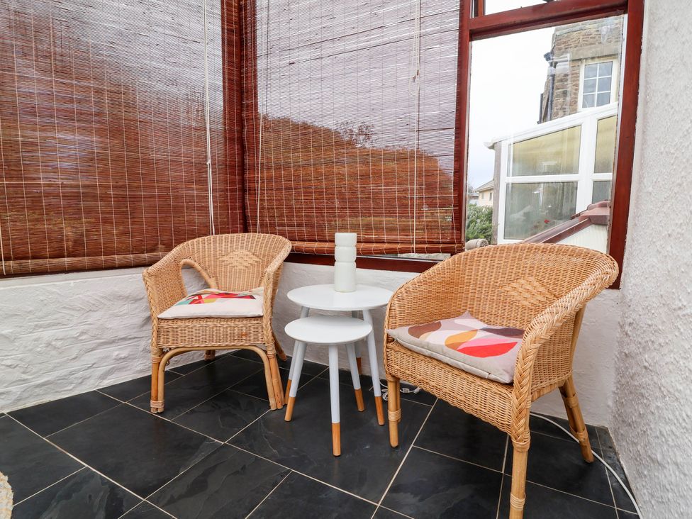 A conservatory with two chairs and a table at The Fort in Bude