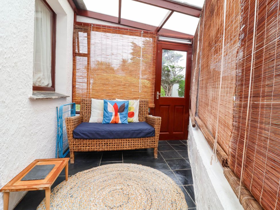 A conservatory with a couch and table at The Fort in Bude