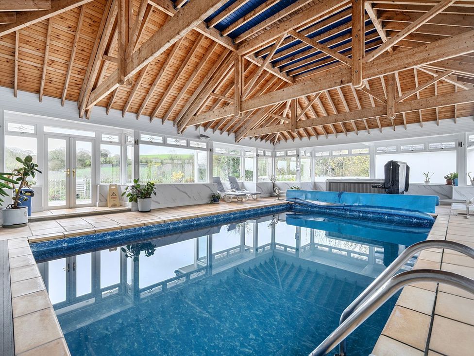 An indoor pool area with a swimming pool and deck chairs at Chapel Green Studio 2 Polgooth