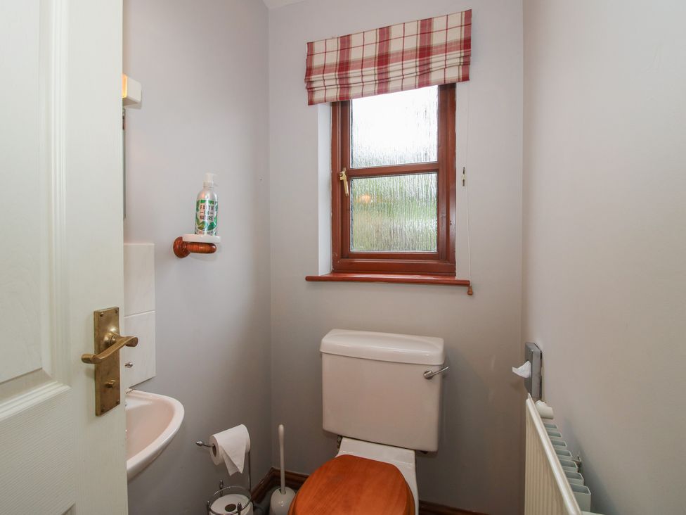 A bathroom with a toilet and sink at Byne Brook Cottage in Strefford near Craven Arms