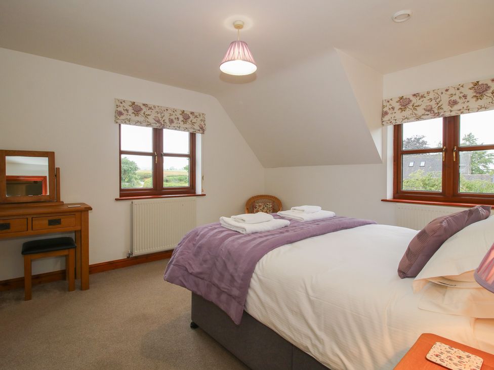 A bedroom with a bed and desk at Byne Brook Cottage in Strefford near Craven Arms