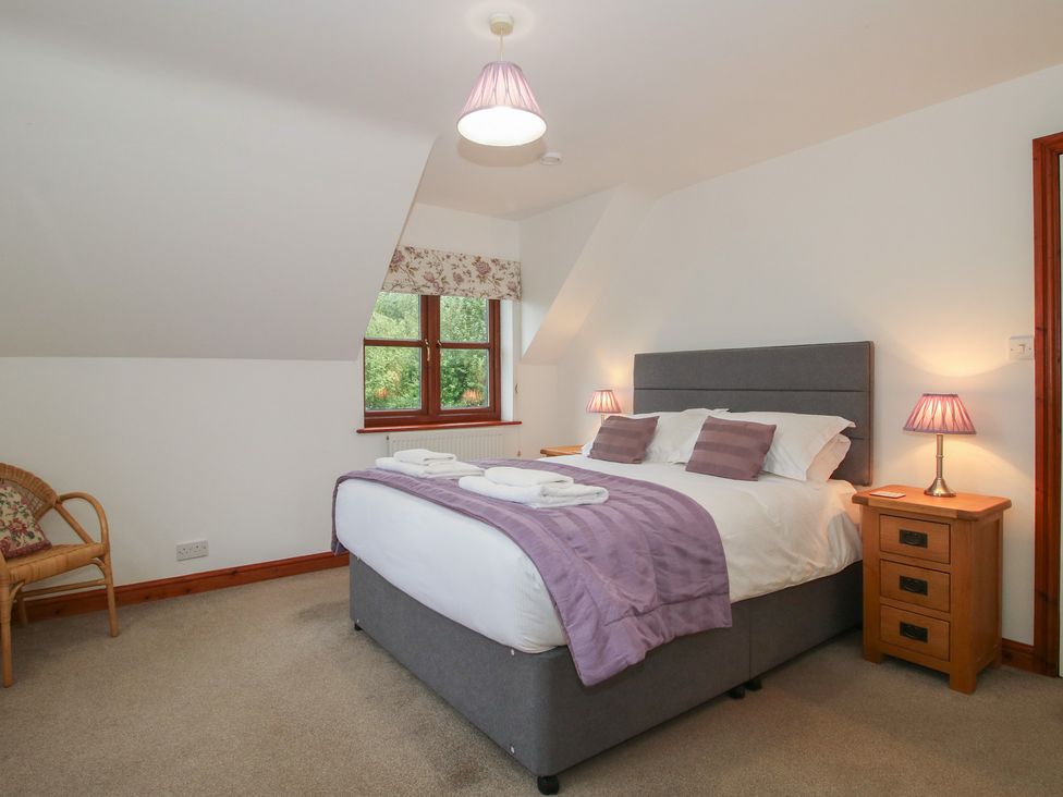 A bedroom with a double bed and side lamps at Byne Brook Cottage in Strefford near Craven Arms