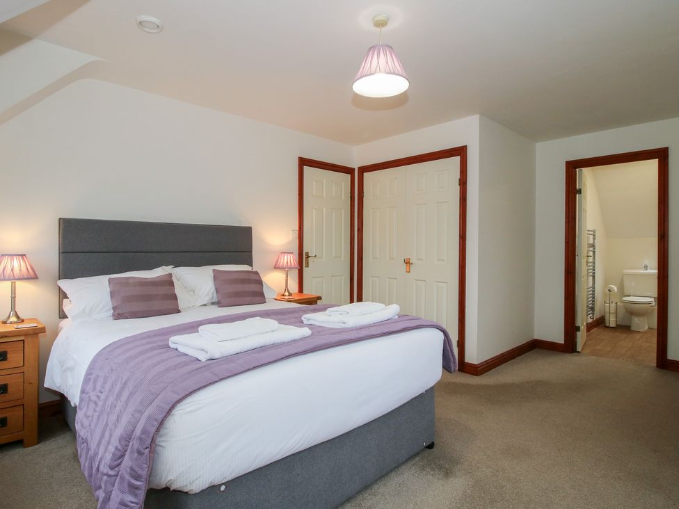 A bedroom with a bed and nightstands at Byne Brook Cottage Strefford near Craven Arms