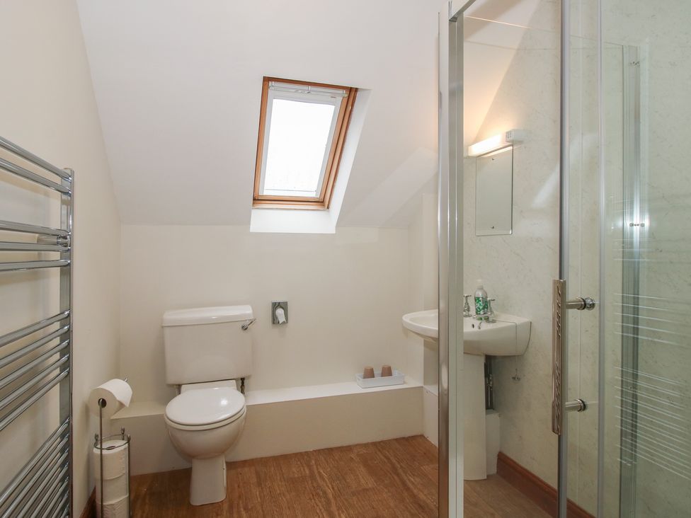 A bathroom featuring a toilet, sink, and shower at Byne Brook Cottage in Strefford near Craven Arms