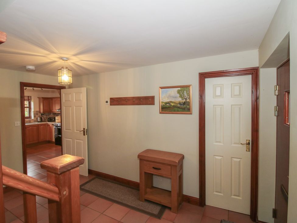 A hallway with a console table and coat rack at Byne Brook Cottage in Strefford near Craven Arms