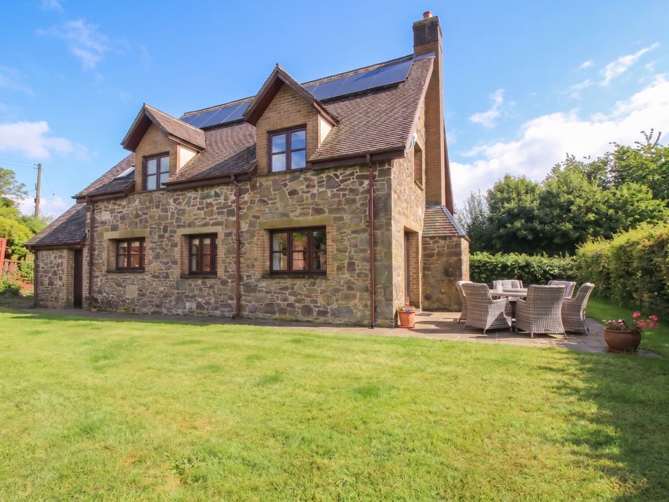 A house with patio furniture and garden at Byne Brook Cottage in Strefford near Craven Arms
