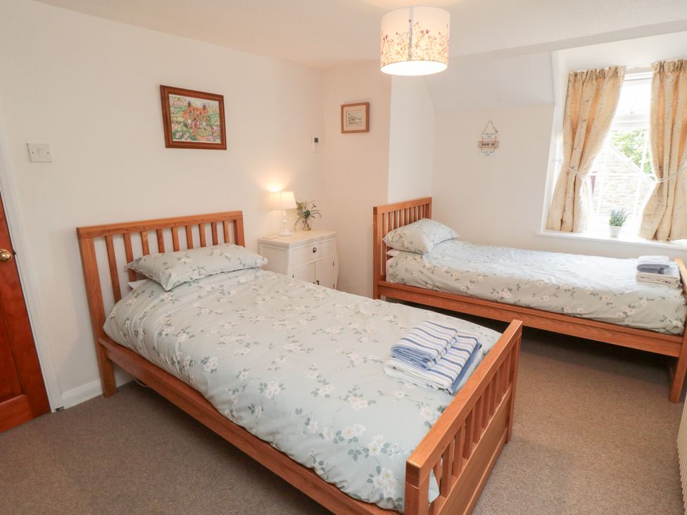 A bedroom with two single beds and a lamp at Fairhaven Cottage in Ugthorpe near Runswick Bay