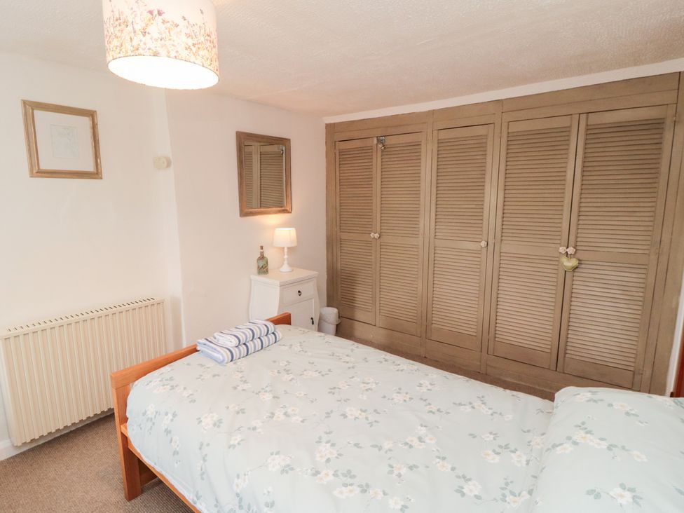 A bedroom with a bed and wardrobe at Fairhaven Cottage Ugthorpe near Runswick Bay