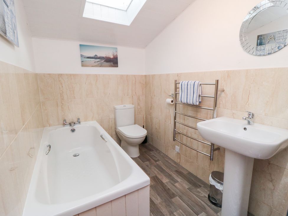 A bathroom with a bathtub, toilet, and sink at Fairhaven Cottage in Ugthorpe near Runswick Bay