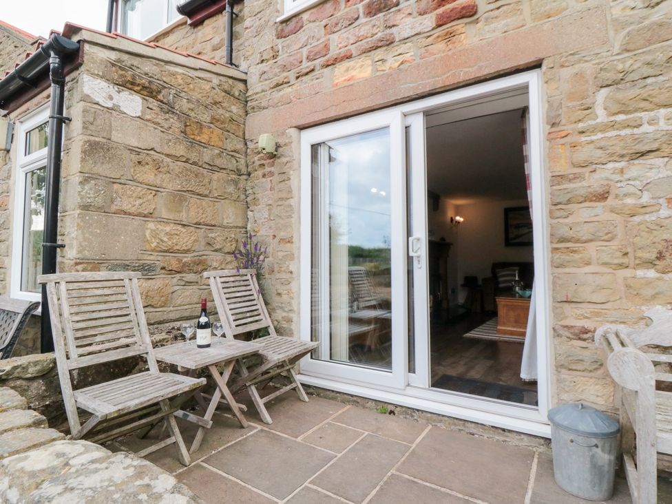An outdoor seating area with chairs and a table at Fairhaven Cottage Ugthorpe near Runswick Bay
