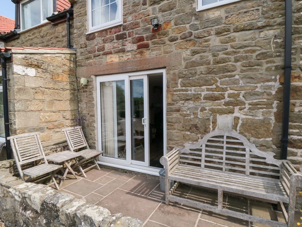 An outdoor seating area with chairs and a bench at Fairhaven Cottage in Ugthorpe near Runswick Bay