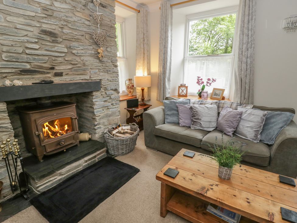 A living room with a fireplace and sofa at Teifi House in Cilgerran near Cardigan