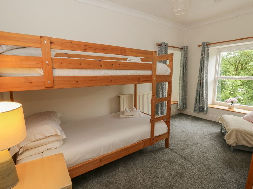 A bedroom with a bunk bed and a single bed at Teifi House in Cilgerran near Cardigan