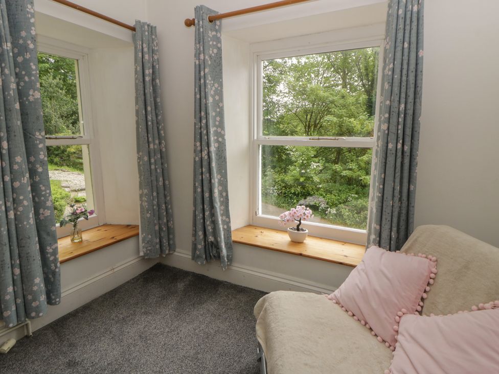 A sitting room with windows and a sofa at Teifi House in Cilgerran near Cardigan