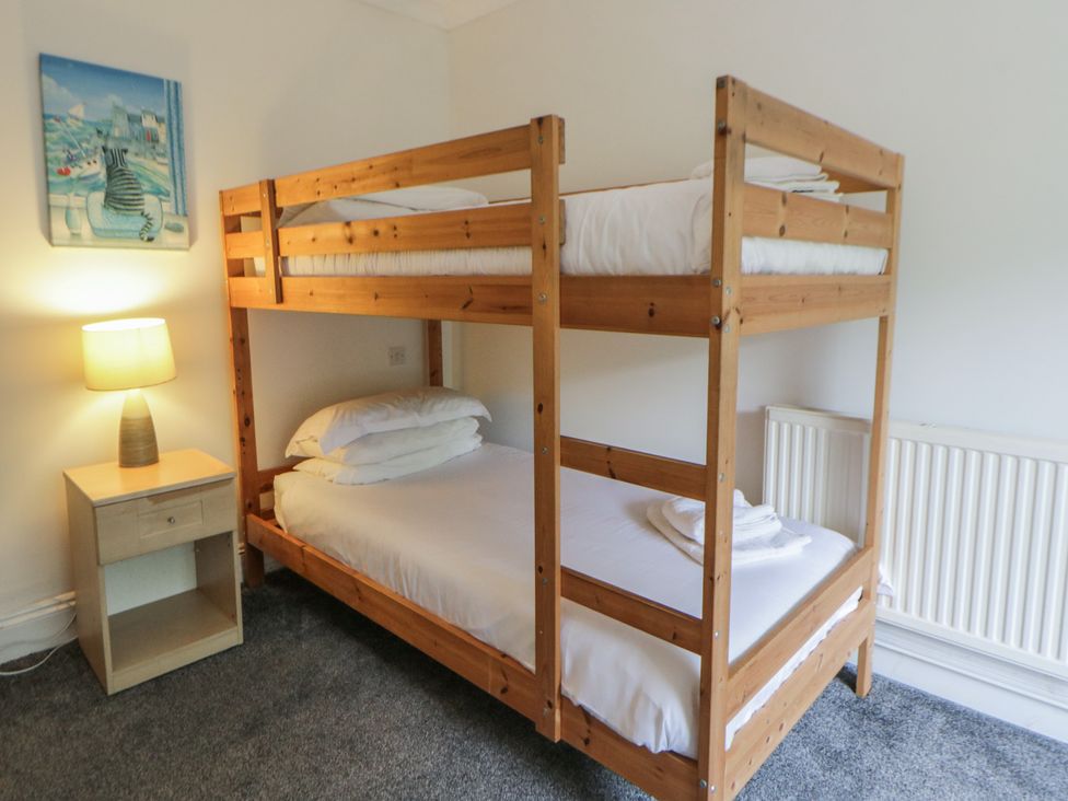 A bunk bed with a nightstand and lamp at Teifi House in Cilgerran near Cardigan
