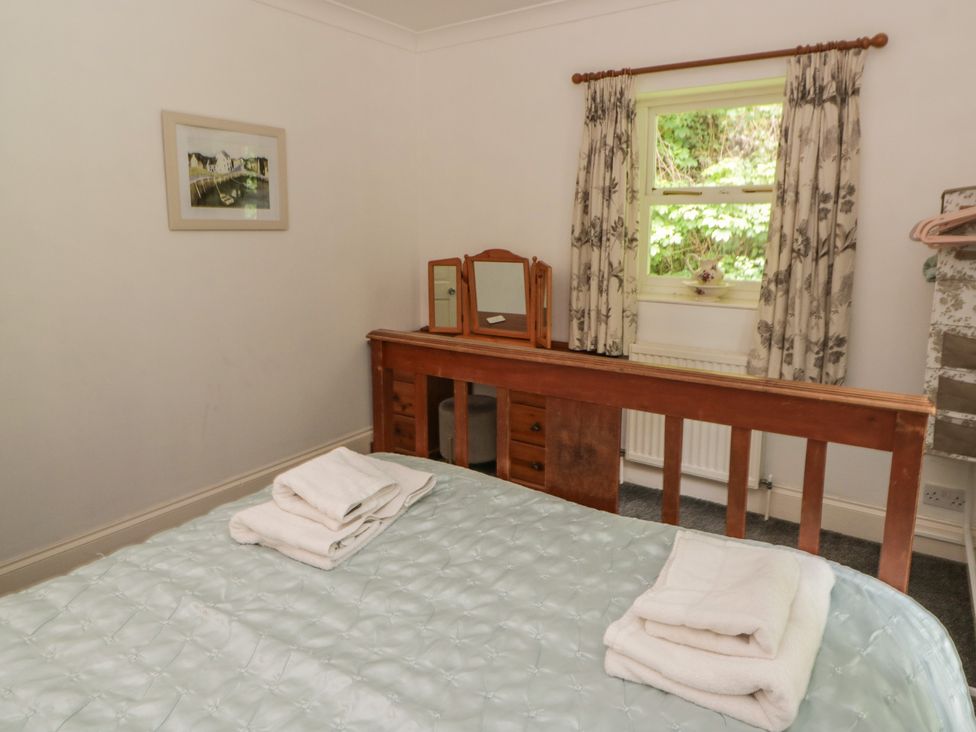 A bedroom with a bed and dressing table at Teifi House in Cilgerran near Cardigan