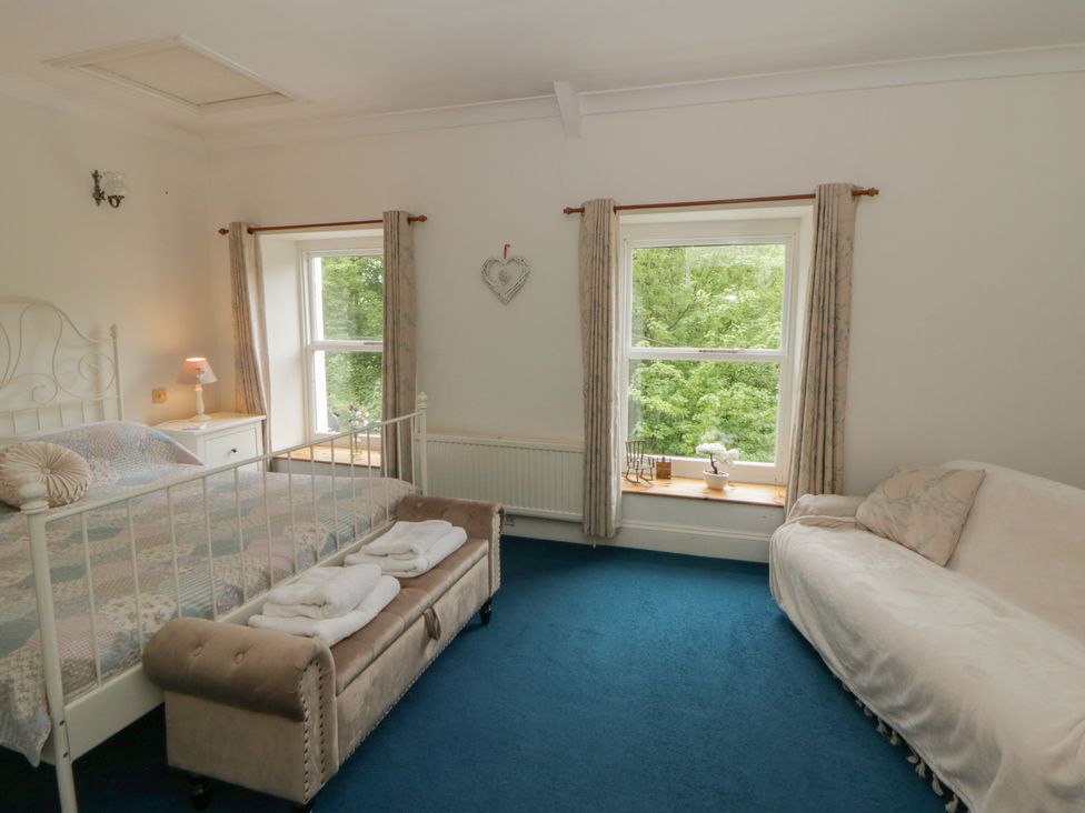 A bedroom with a bed and a sofa at Teifi House in Cilgerran near Cardigan