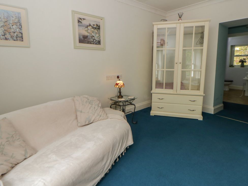 A living room with a sofa and a display cabinet at Teifi House in Cilgerran near Cardigan