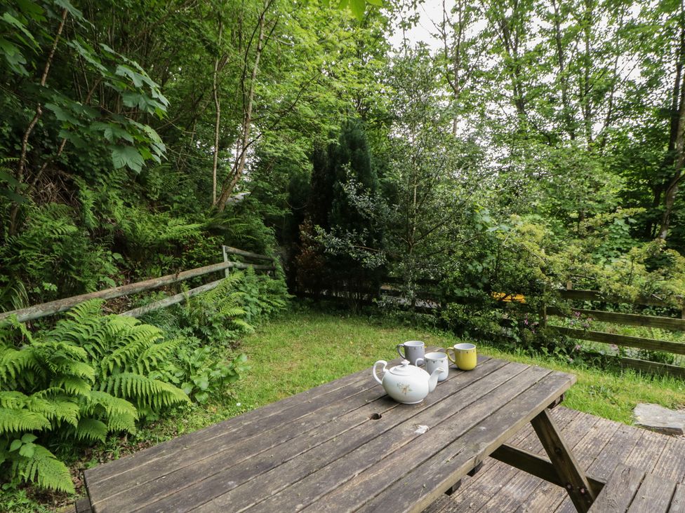 An outdoor area with a wooden table and tea set at Teifi House, Cilgerran near Cardigan