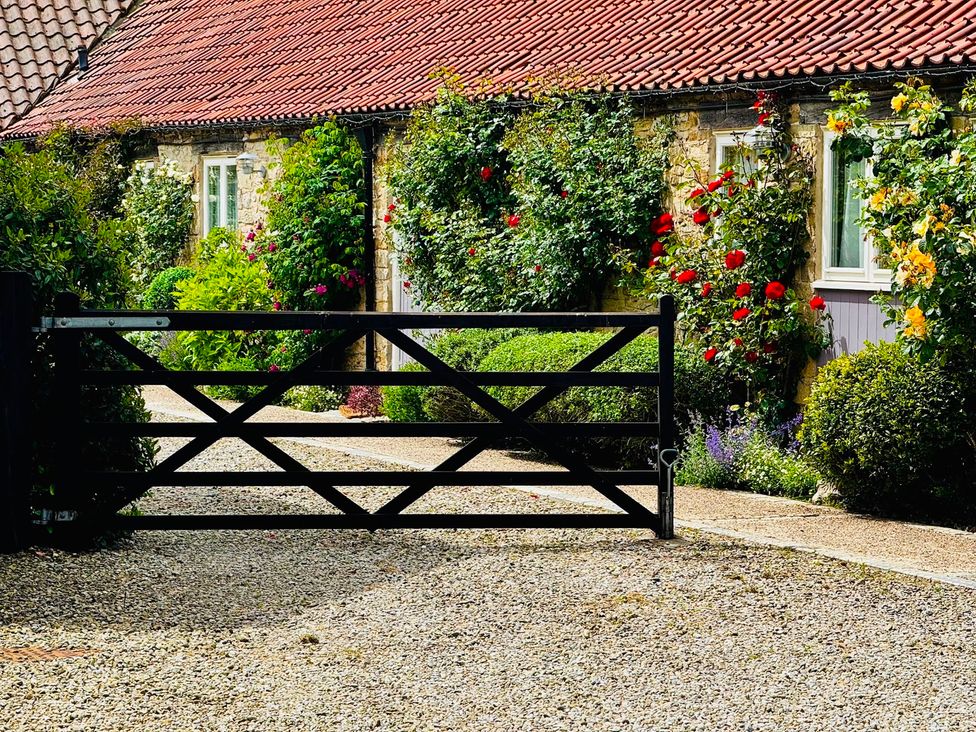 A garden with a gate and flowers at Grouse Cottage near Low Hagg Farm