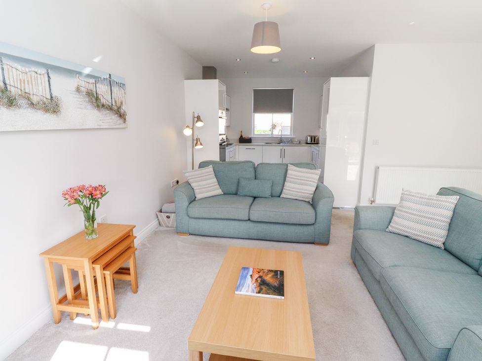 A living room with sofas and a table at The Haven in Embleton