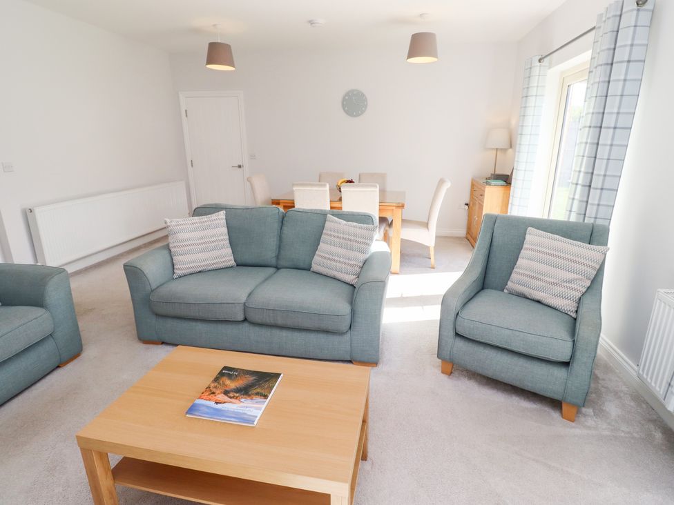 A living room with sofas and a dining table at The Haven in Embleton