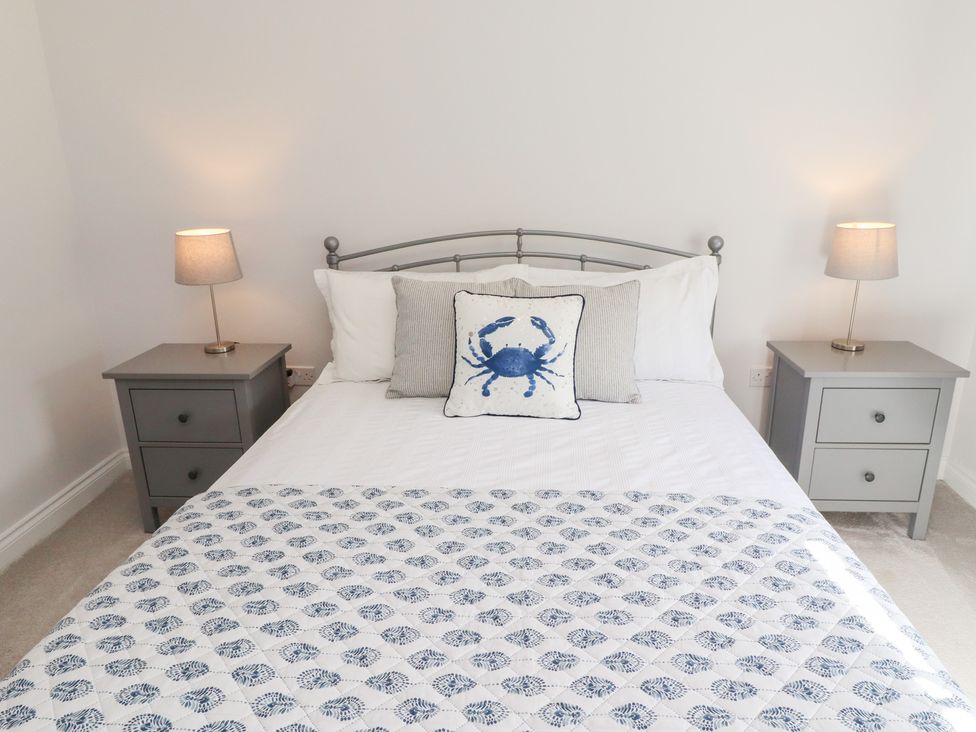 A bedroom with a bed and bedside tables at The Haven in Embleton