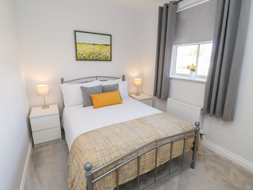 A bedroom with a bed and nightstands at The Haven in Embleton