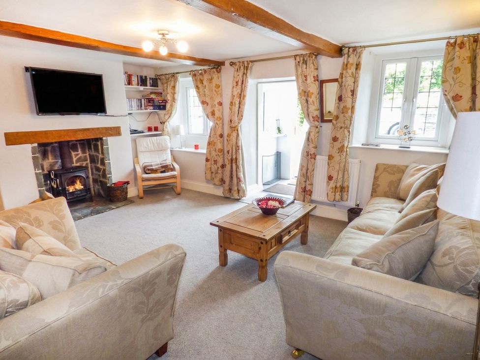 A living room with a sofa and television at High Moor Cottage in Bowness-on-Windermere