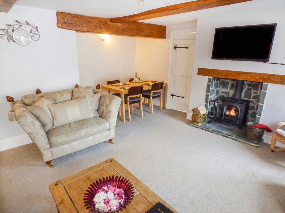 A living room with a sofa and dining table at High Moor Cottage in Bowness-on-Windermere