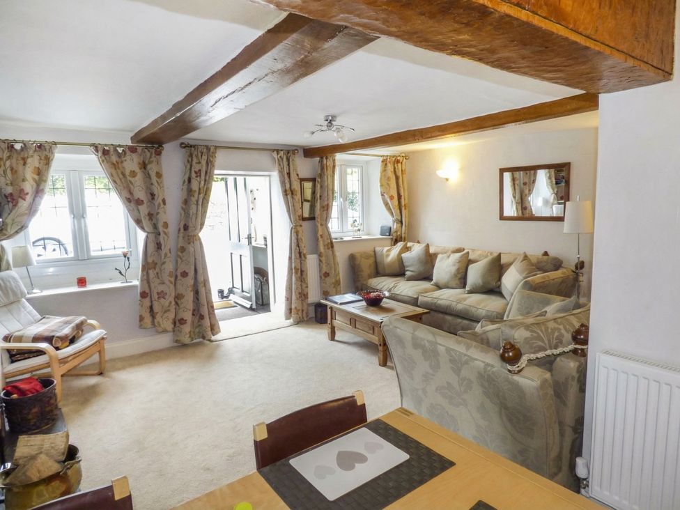 A living room with a sofa and dining table at High Moor Cottage in Bowness-on-Windermere