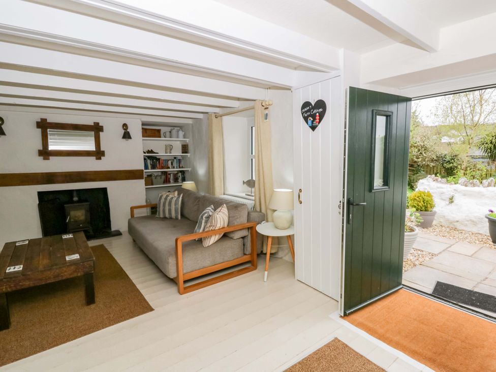 A living room with a sofa and fireplace at Fern Cottage in Aberporth