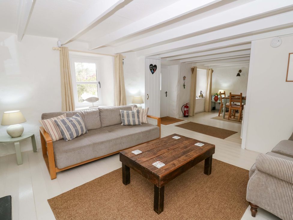 A living room with a sofa and coffee table at Fern Cottage in Aberporth