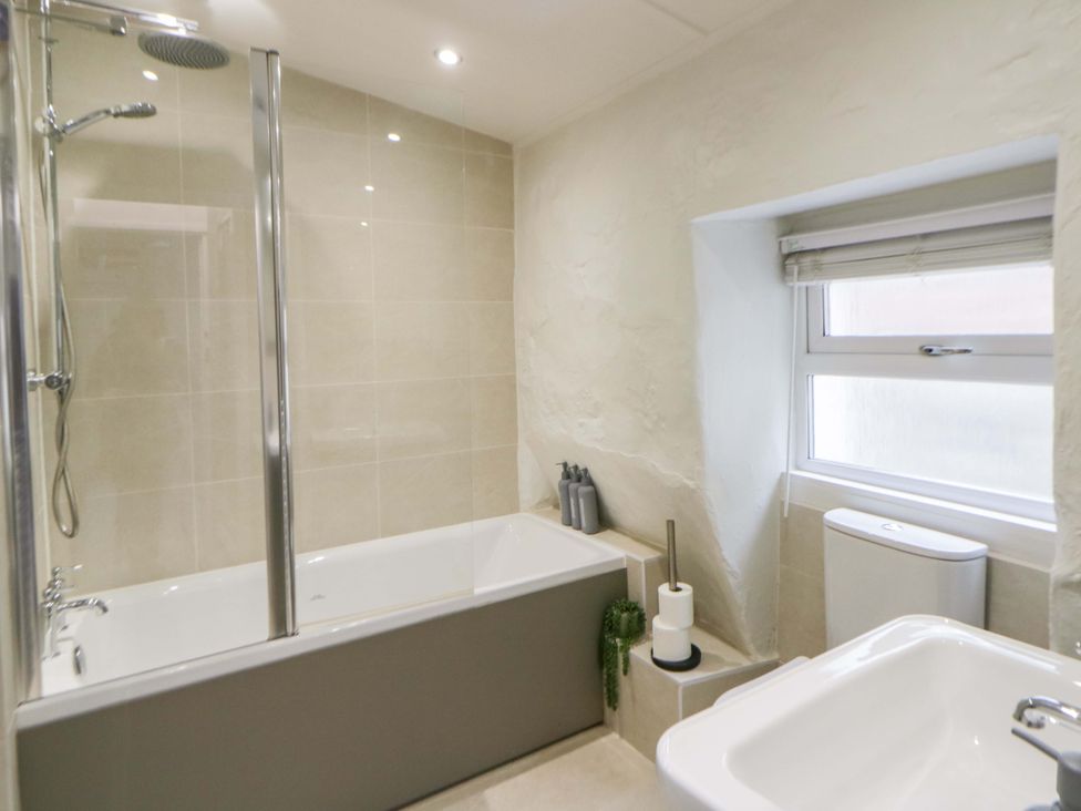 A bathroom with a bathtub and shower at Fern Cottage Aberporth