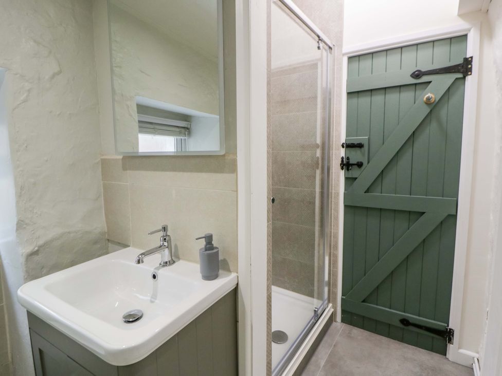 A bathroom with a sink and shower at Fern Cottage in Aberporth