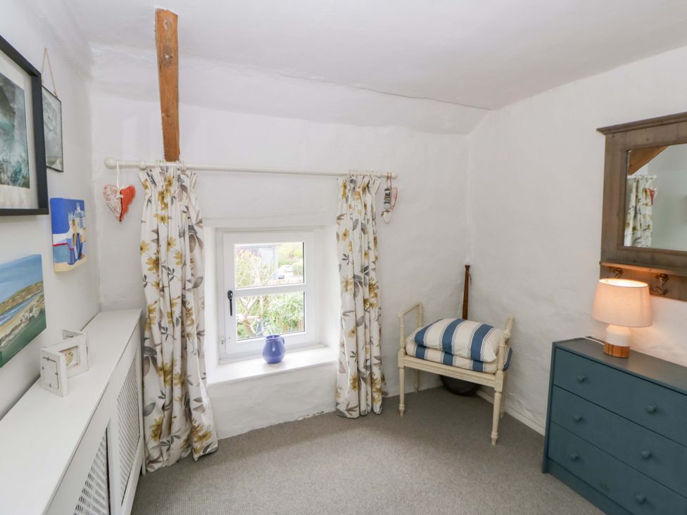 A living room with a window and a chair at Fern Cottage in Aberporth