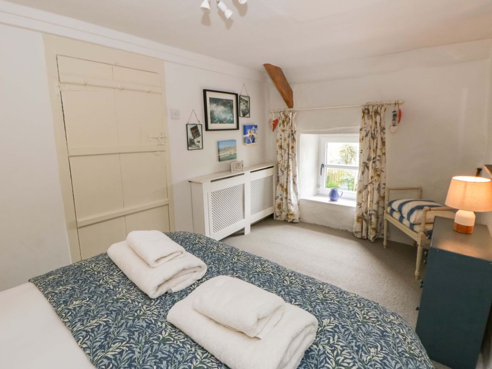 A bedroom with a bed and towels on it at Fern Cottage in Aberporth