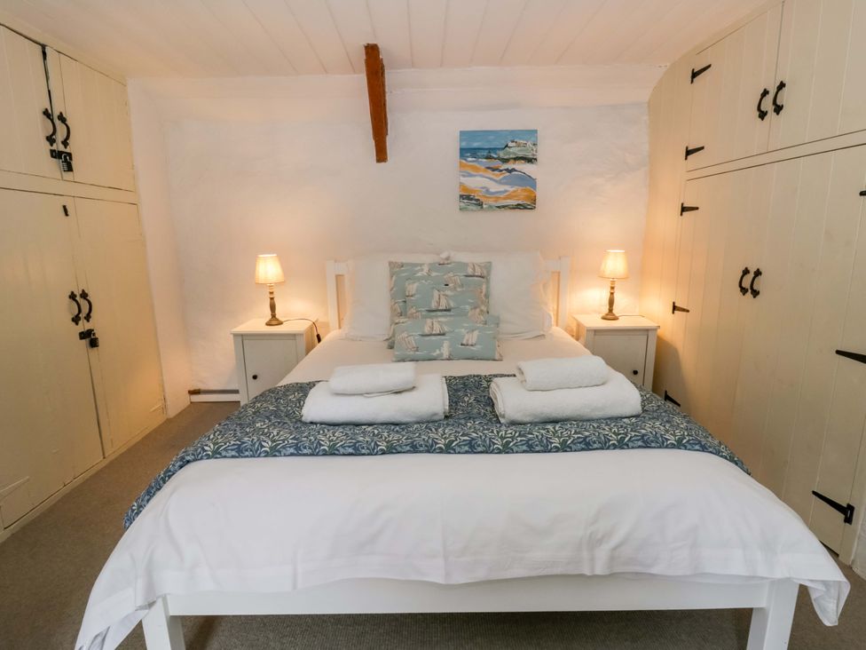 A bedroom with a bed and lamp at Fern Cottage in Aberporth