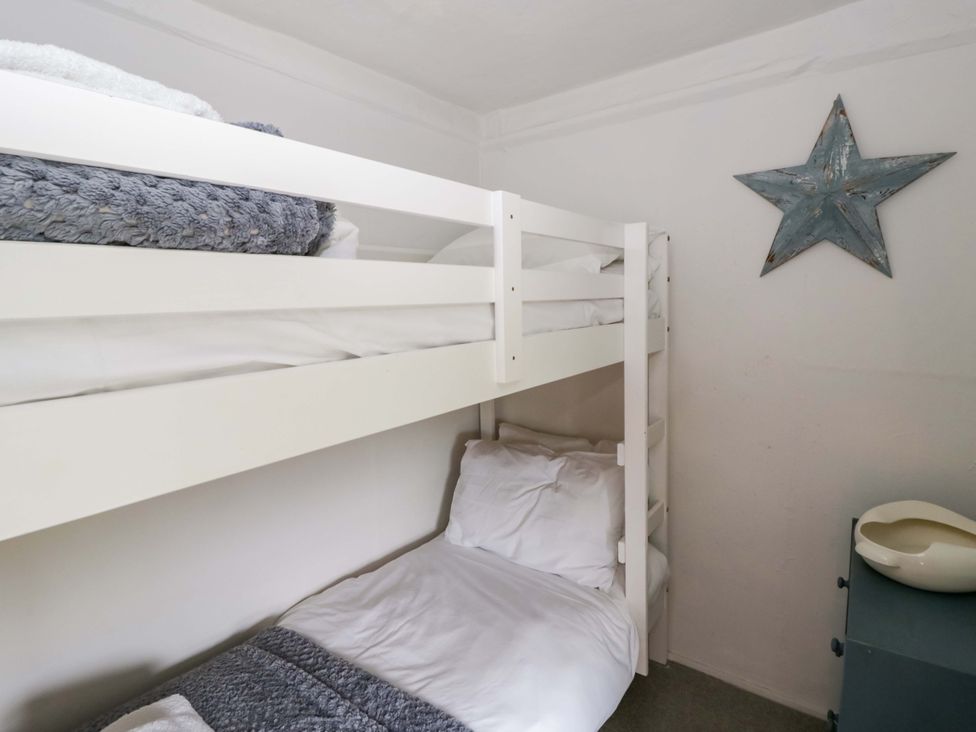 A bedroom with a bunk bed and a blue star decoration at Fern Cottage Aberporth