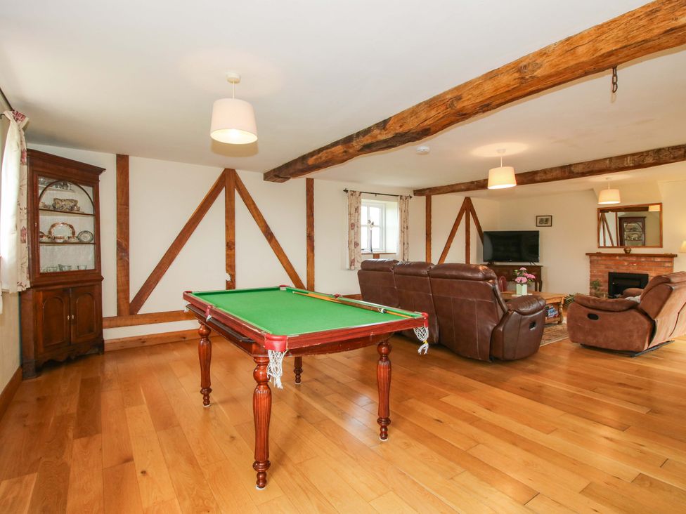 A living room with a pool table and sofa at The Barn Cockshutt near Ellesmere