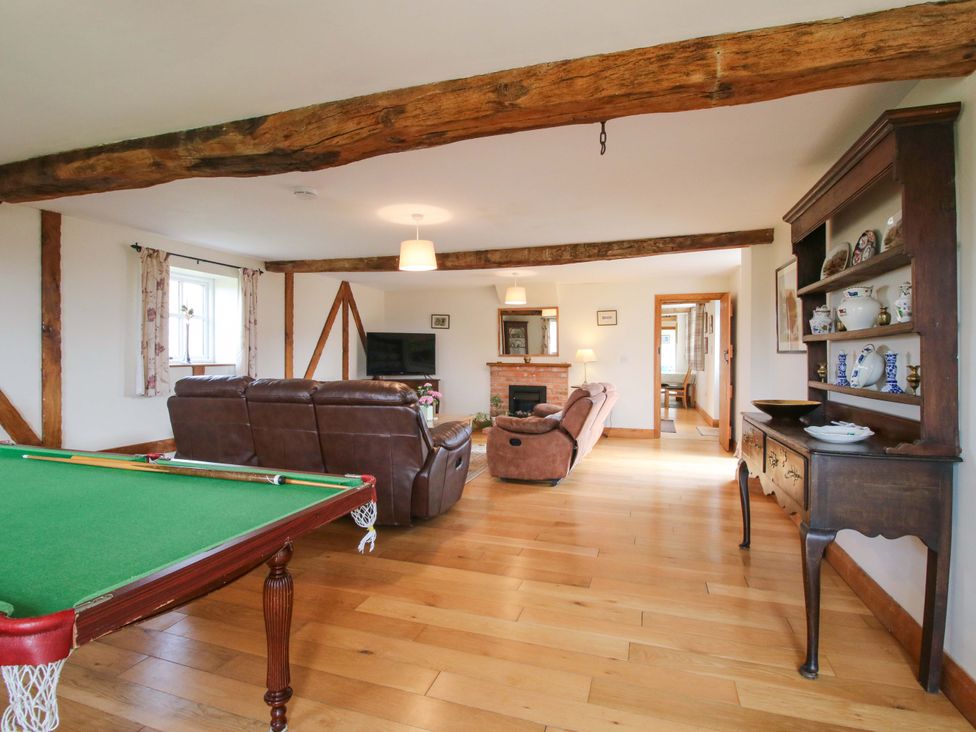 A living room with a pool table and sofa at The Barn in Cockshutt near Ellesmere