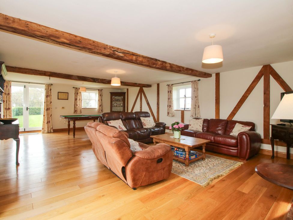 A living room with two sofas and a table at The Barn in Cockshutt near Ellesmere