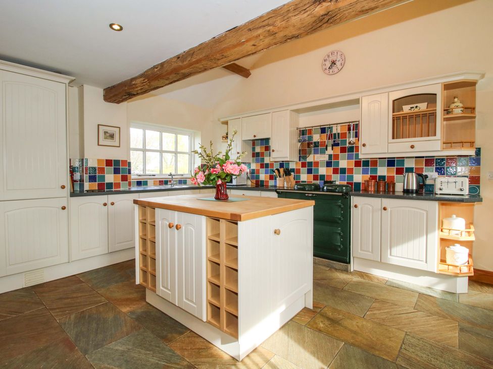 A kitchen with an island and colorful tiles at The Barn in Cockshutt near Ellesmere