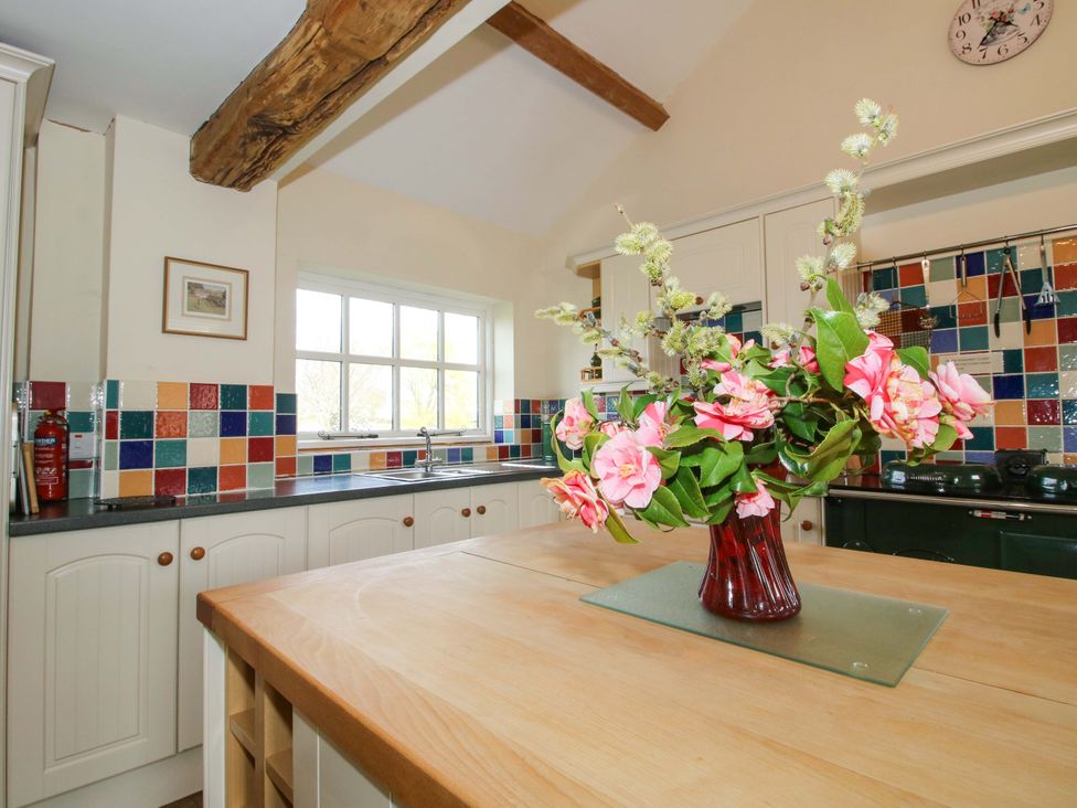 A kitchen with a sink and colorful tiles at The Barn Cockshutt near Ellesmere